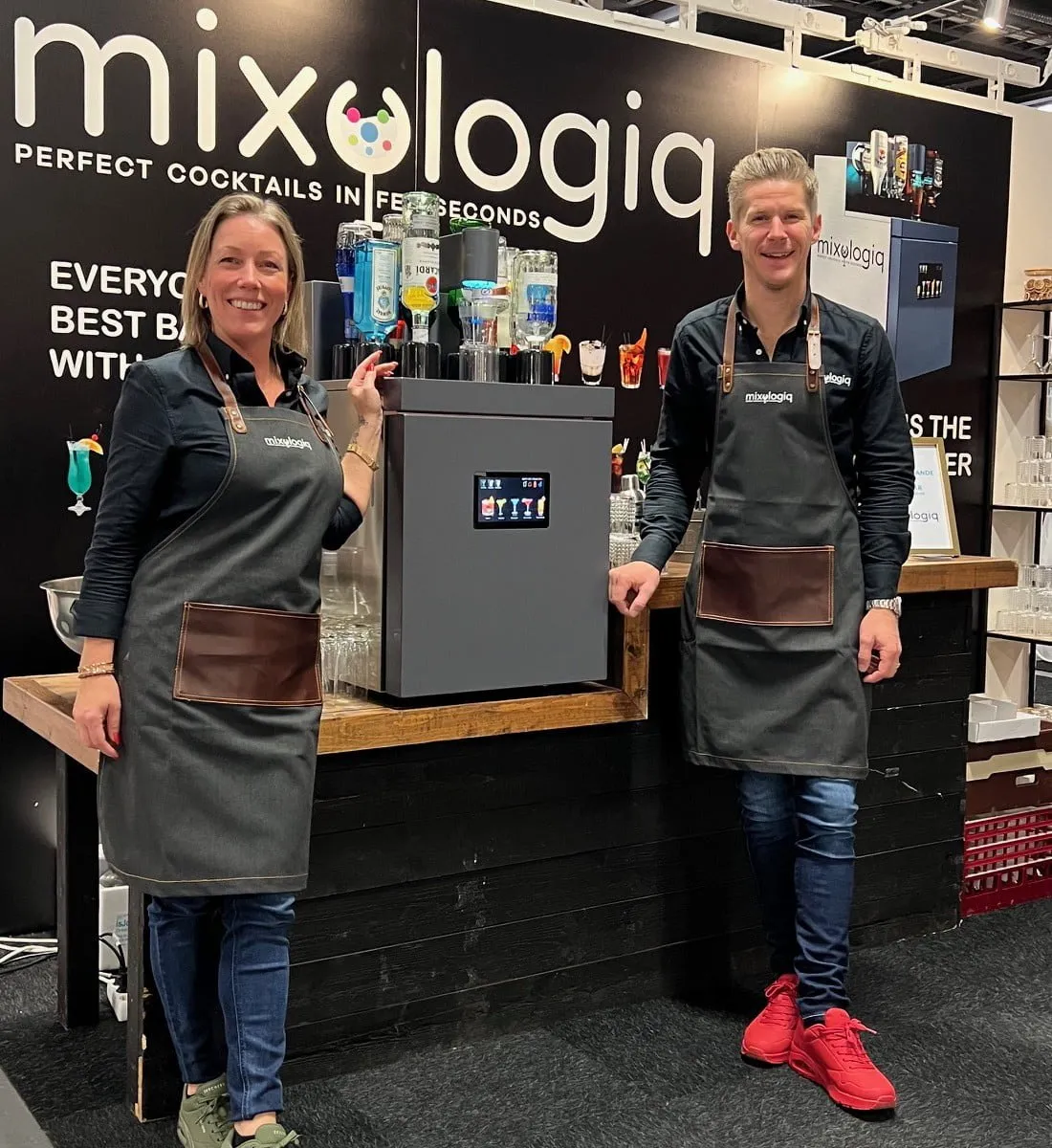 Två medarbetare vid Mixologiq-maskinen under ett event